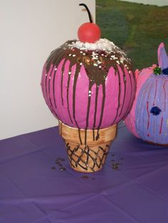 two colorful vases sitting on top of a purple table cloth covered in icing and sprinkles