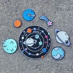 an assortment of outer space magnets are on the ground in front of a black and white plate