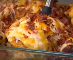 a casserole dish with meat, cheese and bacon in it is being eaten