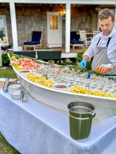 a man in an apron preparing food on a buffet table