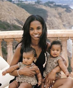 a woman holding two small children on her lap