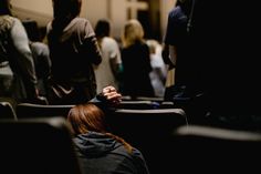 a group of people standing and sitting in a room with their backs to each other