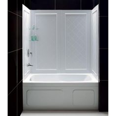 a white bath tub sitting next to a black tiled wall in a bathroom with tile flooring