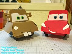 two paper cars sitting on top of a table