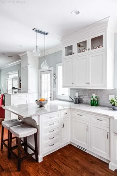 a large kitchen with white cabinets and wood flooring, along with a breakfast nook