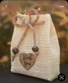 a small bag with a wooden heart on the front and thank you written on it