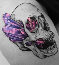 a woman's thigh with a skull and crystals on it