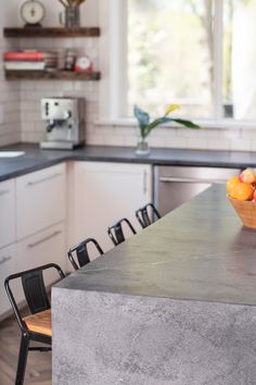 a bowl of fruit sitting on top of a kitchen counter