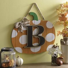 a wooden sign hanging on the side of a wall next to vases with flowers