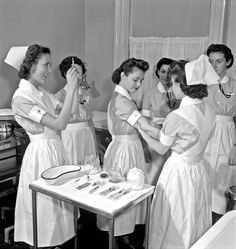 several women in nurses uniforms standing around a table