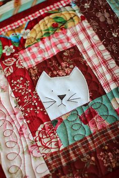 a close up of a quilt with a cat on it