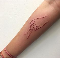 a woman's arm with a tattoo on it that has two hands holding each other