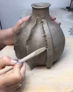 someone is making a vase out of clay