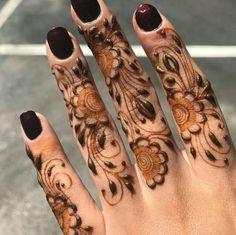 a woman's hand with henna tattoos on it