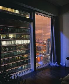 a room with a large window overlooking the city at night