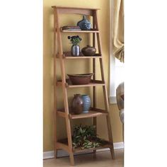 a tall wooden shelf with pots and vases on it