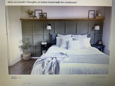 a bed with white sheets and pillows in a bedroom next to a wooden headboard