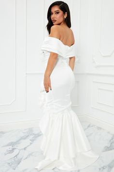 a woman in a white dress standing on a marble floor with her back to the camera