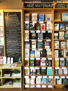 the bookshelf is filled with many different types of books and has a chalkboard on it