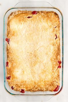 an uncooked pie in a glass dish on a white counter top with crumbs