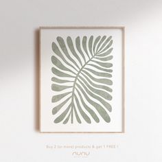 a green leaf print hanging on the wall