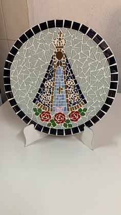 a decorative plate sitting on top of a white counter next to a tile covered wall