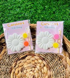 two bags of candy sitting on top of a basket next to each other in the grass