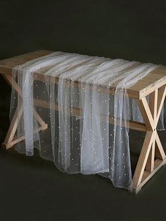 a wooden bench with sheer curtains on it