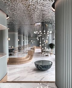 the interior of a modern restaurant with marble floors and walls, chandeliers hanging from the ceiling