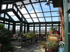 the inside of a greenhouse with lots of plants and potted plants in pots on tables