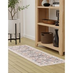 a wooden book shelf filled with books on top of a hard wood floor next to a potted plant