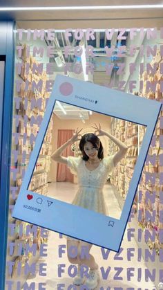 a woman standing in front of a store window with her hands behind her head and wearing a white dress