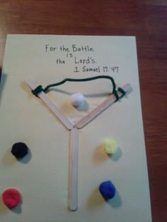 a handmade card with some sort of string attached to it and balls on top