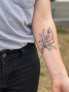 a woman's arm with a bird on it and flowers tattooed on the wrist