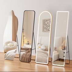 three mirrors sitting on top of a hard wood floor next to a bed and chair