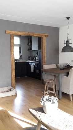 an open kitchen and dining room with wood flooring in the living room, dinning area