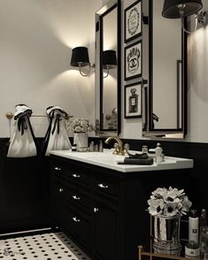 a bathroom with black and white tile flooring and wall mounted mirrors above the sink