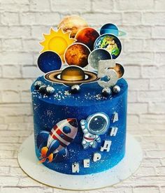 a blue cake with space themed decorations on it