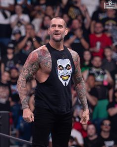 the wrestler is standing in front of an audience with his face painted on it's chest