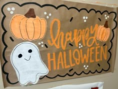 a halloween bulletin board on the wall with ghost and pumpkins painted on it's sides