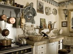 an old fashioned kitchen with pots and pans on the wall