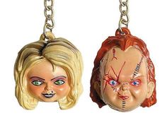 two key chains with the faces of people wearing scary masks on them, one is blonde and the other has blue eyes