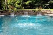 an outdoor swimming pool with water features