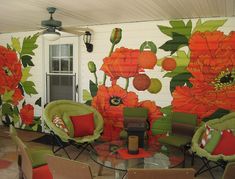 a living room filled with furniture and flowers painted on the wall