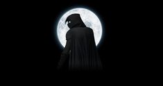 a person in a black hooded suit standing in front of a full moon