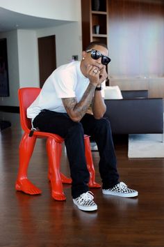 a man sitting on top of a red chair