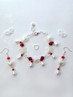 a bracelet and earring set with red beads on a white surface, including one bead