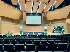 an empty auditorium with rows of chairs and a projector screen