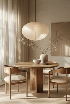 a dining room table with two chairs and a vase on the table next to it