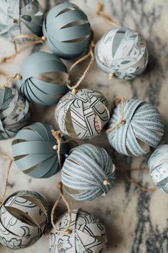 some ornaments are hanging from twine on the floor with string and paper balls in front of them